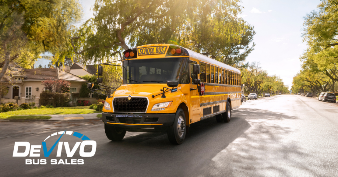 electric IC school bus driving down a residential road on a sunny day